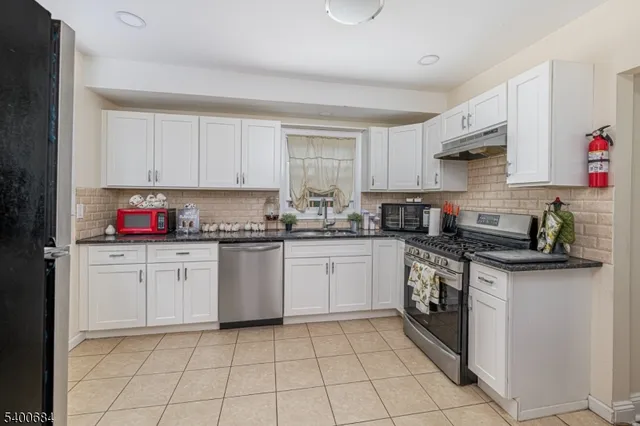 a kitchen with granite countertop cabinets stainless steel appliances and a sink