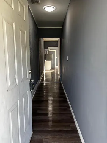a view of a hallway with wooden floor and staircase