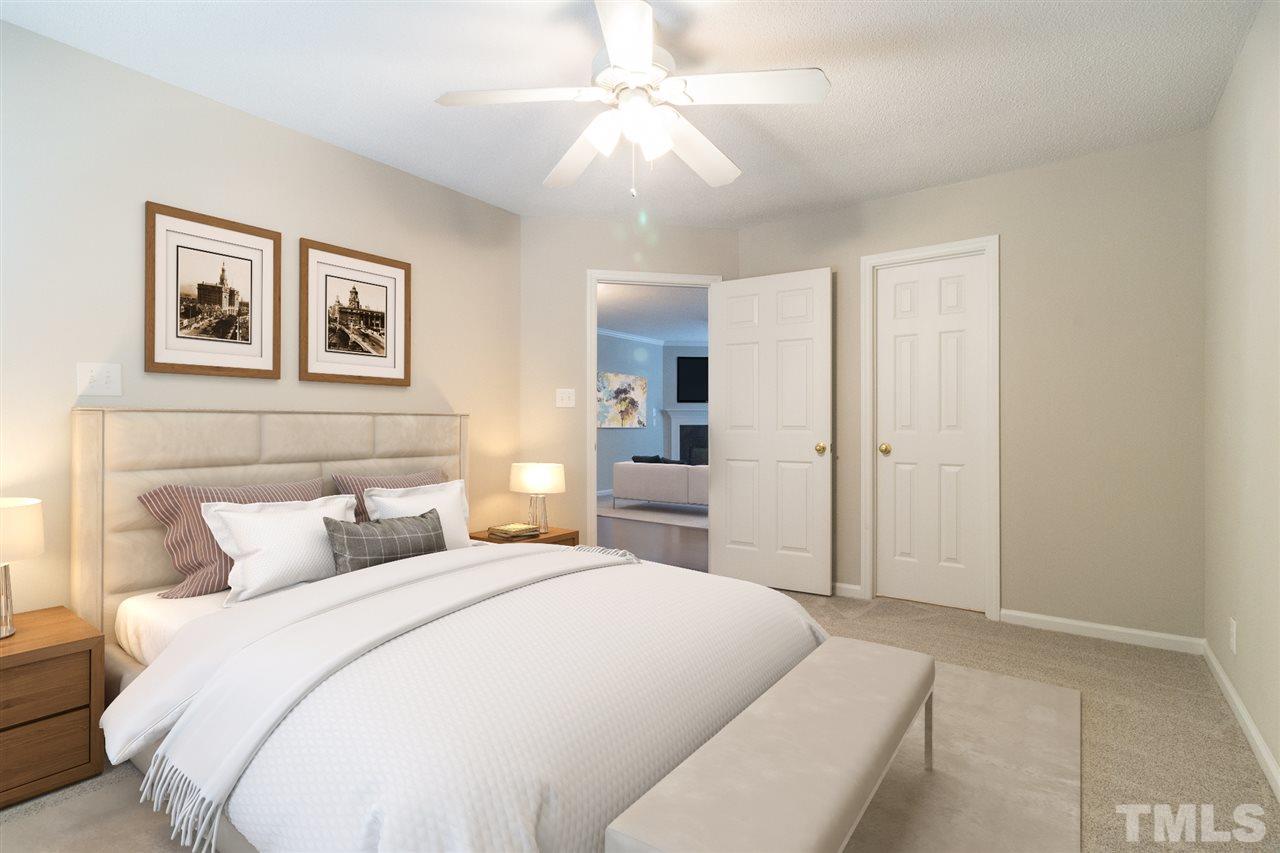 4451 Antique Lane Raleigh, NC 27616 - Photo 11 of 24 a bedroom with a large bed and a chandelier