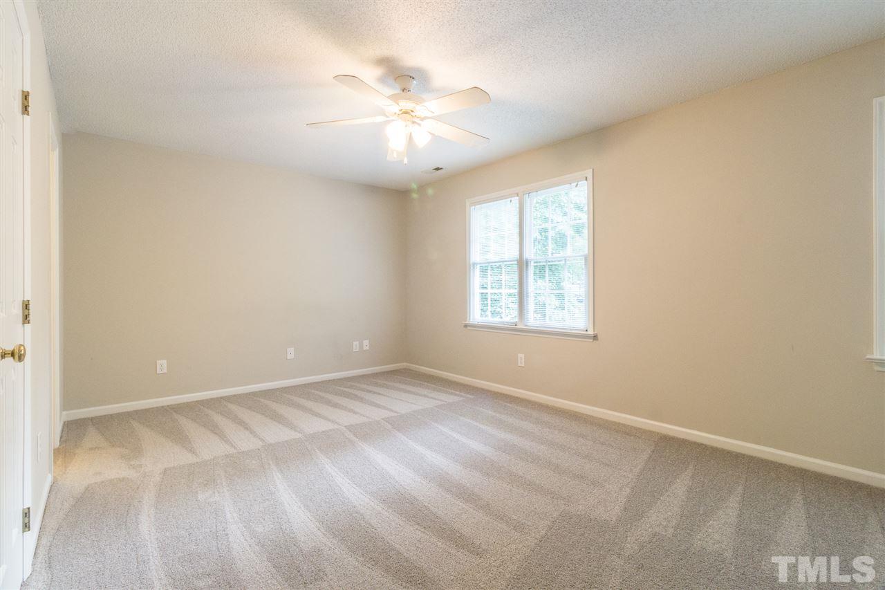 4451 Antique Lane Raleigh, NC 27616 - Photo 13 of 24 an empty room with windows and chandelier fan