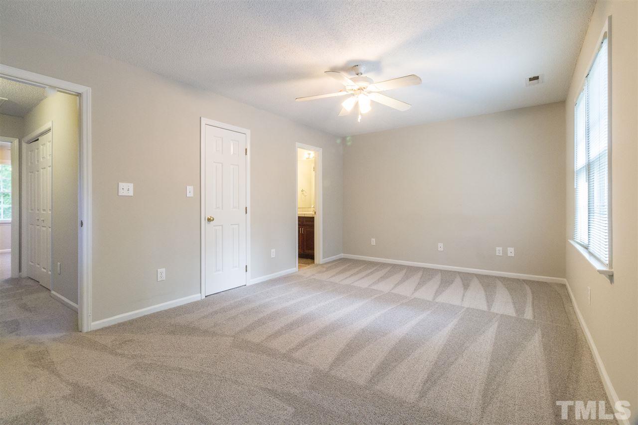 4451 Antique Lane Raleigh, NC 27616 - Photo 14 of 24 an empty room with chandelier fan and windows