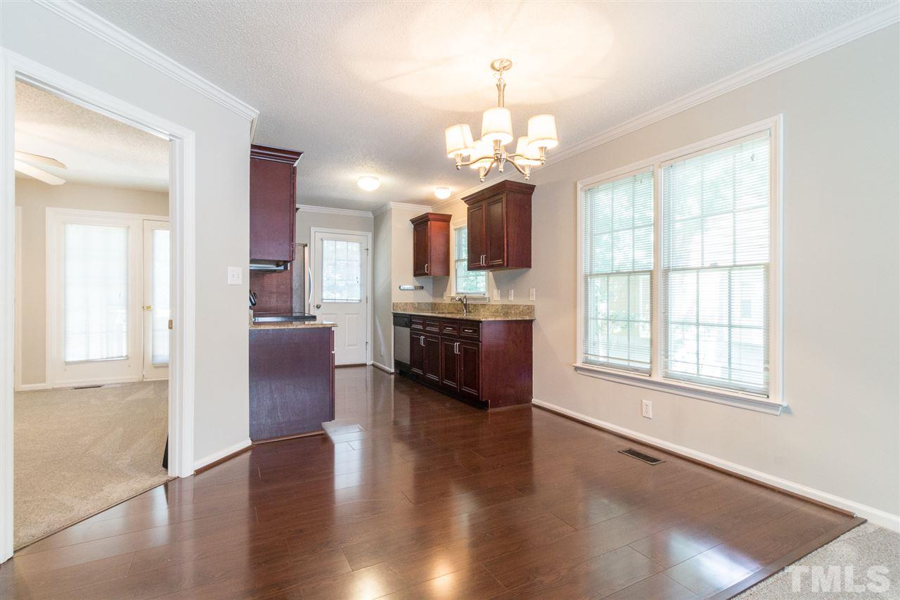 4451 Antique Lane Raleigh, NC 27616 - Photo 6 of 24 a large kitchen with stainless steel appliances granite countertop a oven a stove and a refrigerator with wooden floor