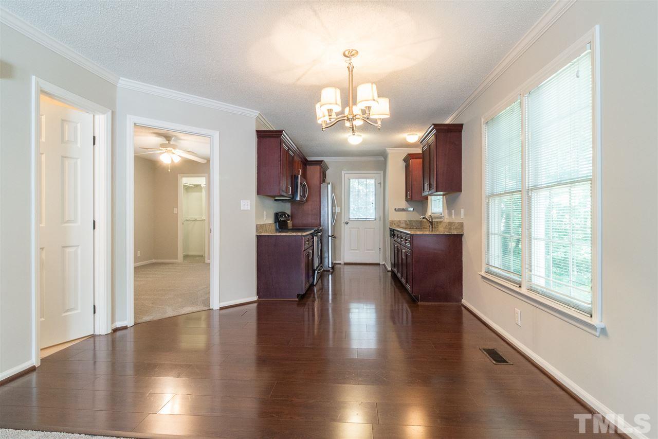 4451 Antique Lane Raleigh, NC 27616 - Photo 7 of 24 a view of a room with wooden floor a ceiling fan and windows