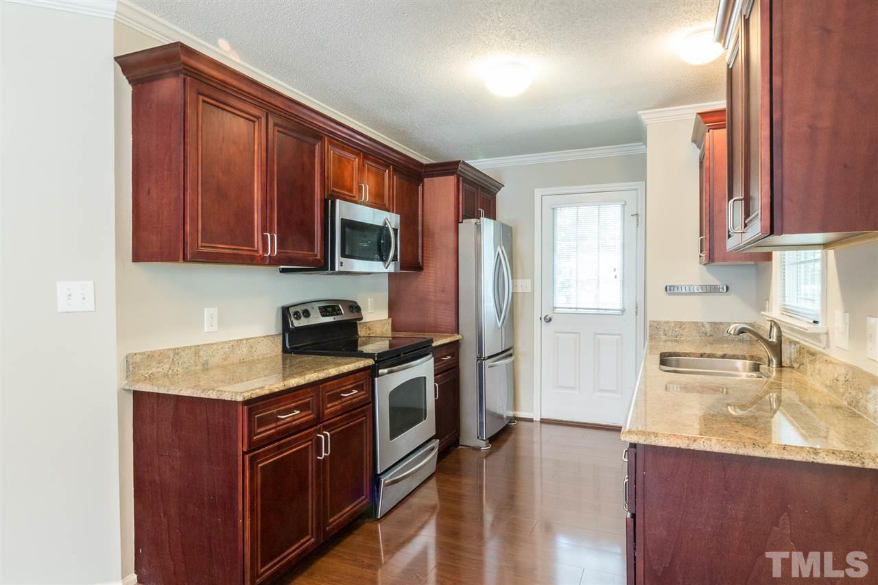 4451 Antique Lane Raleigh, NC 27616 - Photo 8 of 24 a kitchen with stainless steel appliances granite countertop a sink stove and refrigerator