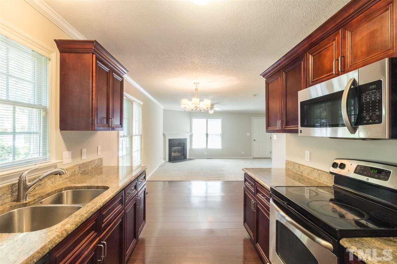 4451 Antique Lane Raleigh, NC 27616 - Photo 10 of 24 a large kitchen with granite countertop a sink and a stove top oven a granite counter space