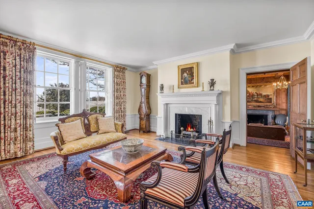 a living room with furniture a fireplace and a chandelier