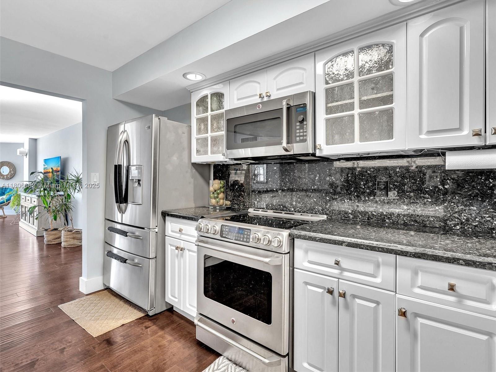 6423 Collins Avenue, Unit 409 Miami Beach, FL 33141 - Photo 16 of 66 a kitchen with stainless steel appliances granite countertop a stove a sink and a refrigerator