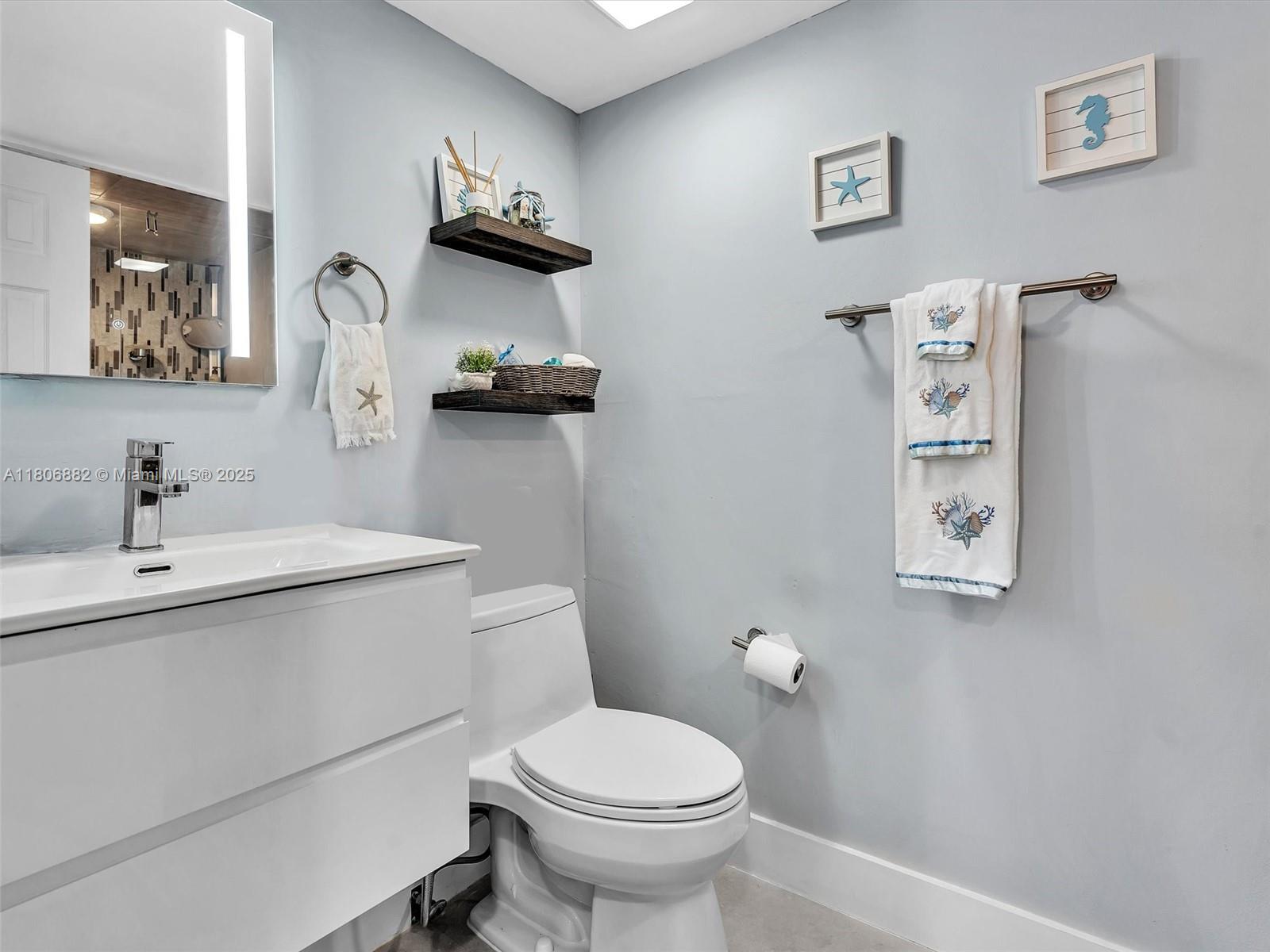 6423 Collins Avenue, Unit 409 Miami Beach, FL 33141 - Photo 29 of 66 a bathroom with a toilet a sink and mirror