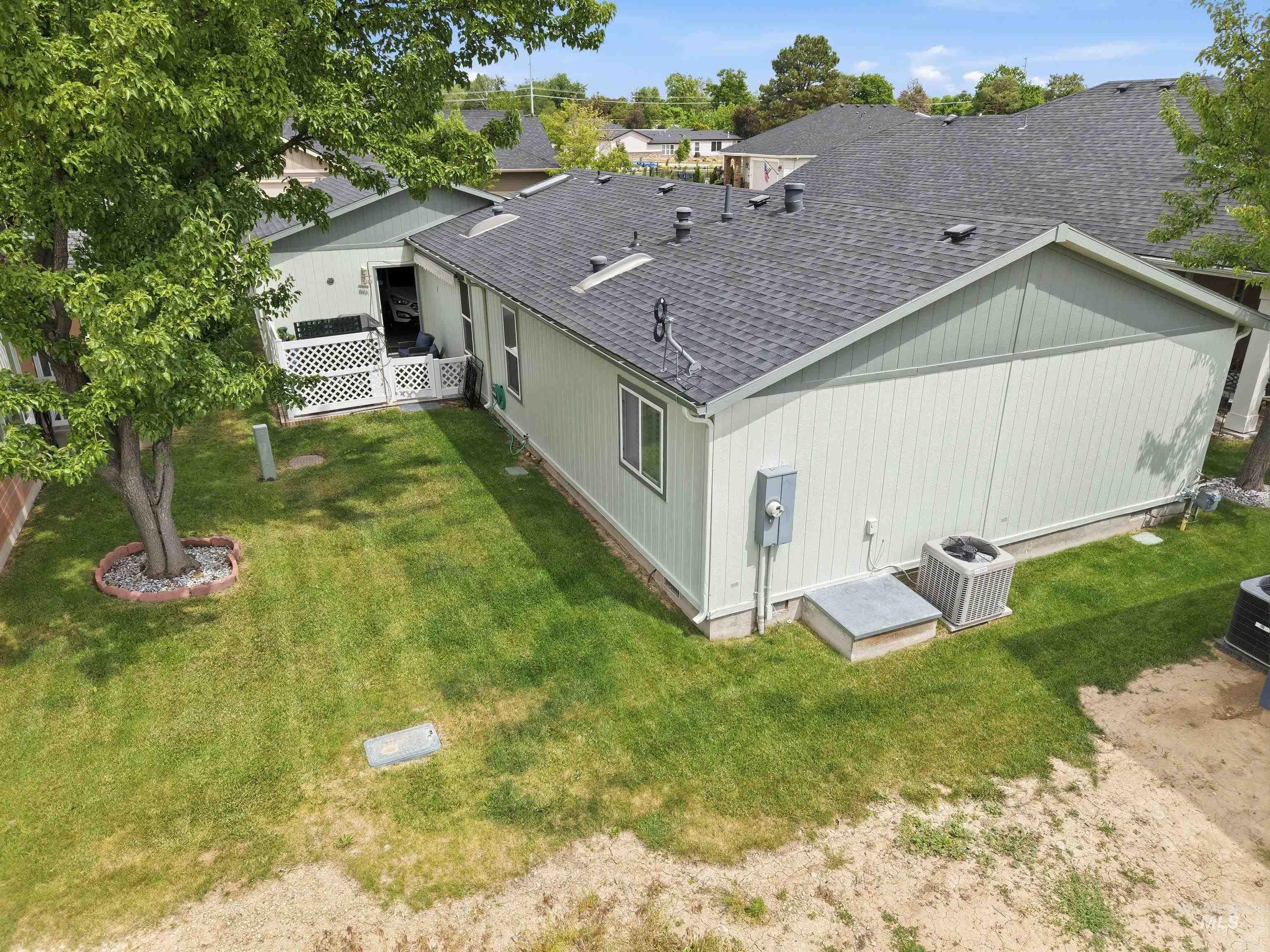 421 South Curtis Road, Unit 202 202 Boise, ID 83705 - Photo 35 of 41 Spacious backyard featuring a manicured lawn, established shade tree with rock bed, and white lattice fencing
