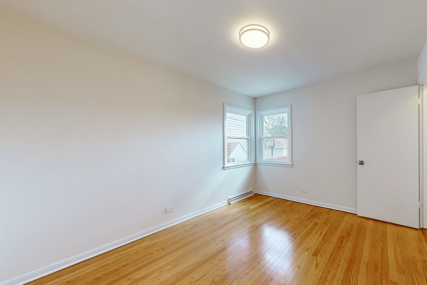 6249 West Addison Street Chicago, IL 60634 - Photo 15 of 35 an empty room with wooden floor and windows