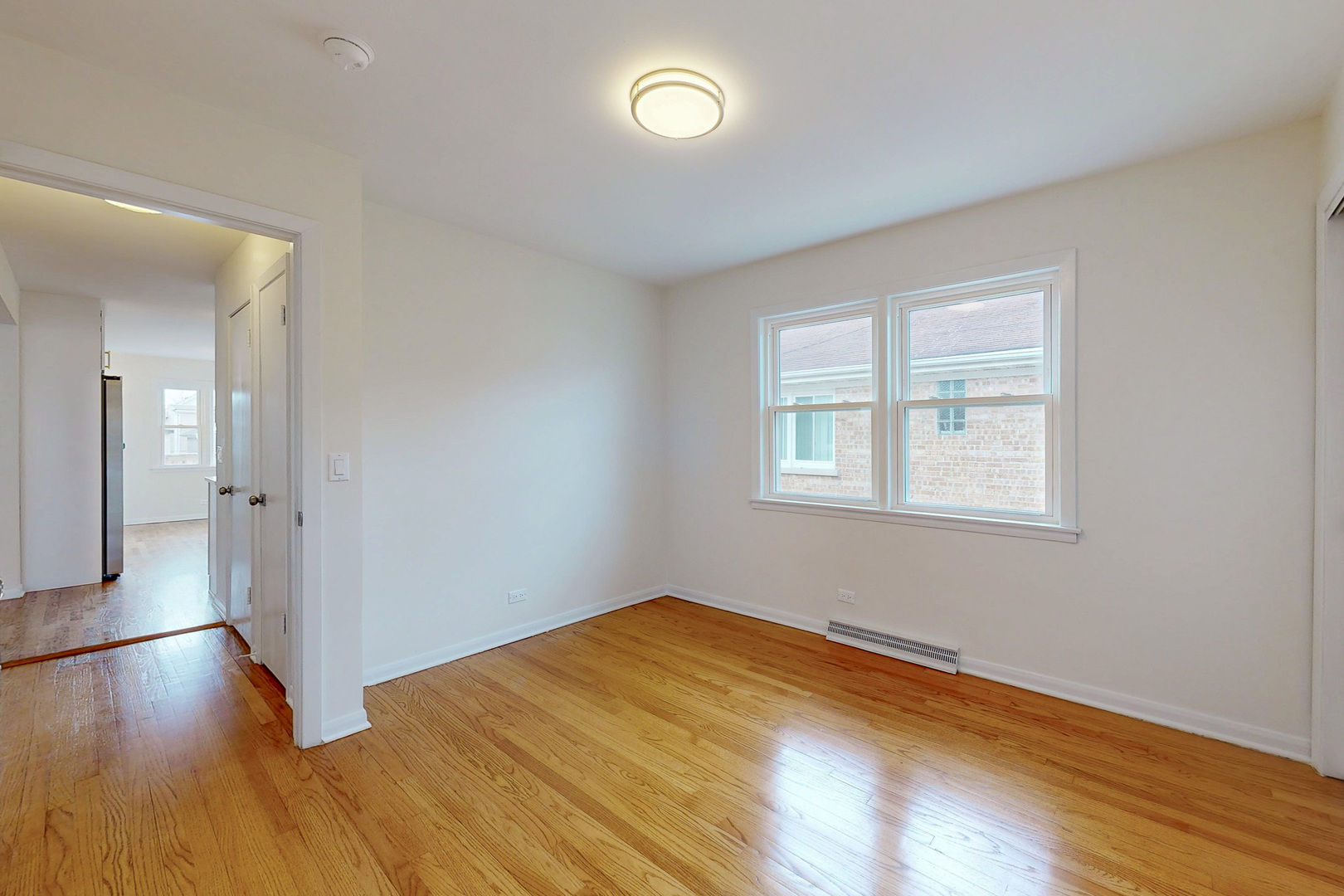 6249 West Addison Street Chicago, IL 60634 - Photo 17 of 35 an empty room with wooden floor and windows