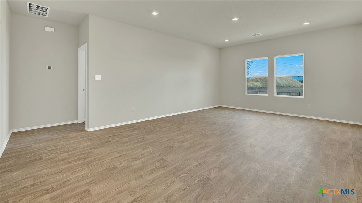 521 Hodges Street Lockhart, TX 78644 - Photo 19 of 40 an empty room with wooden floor and windows