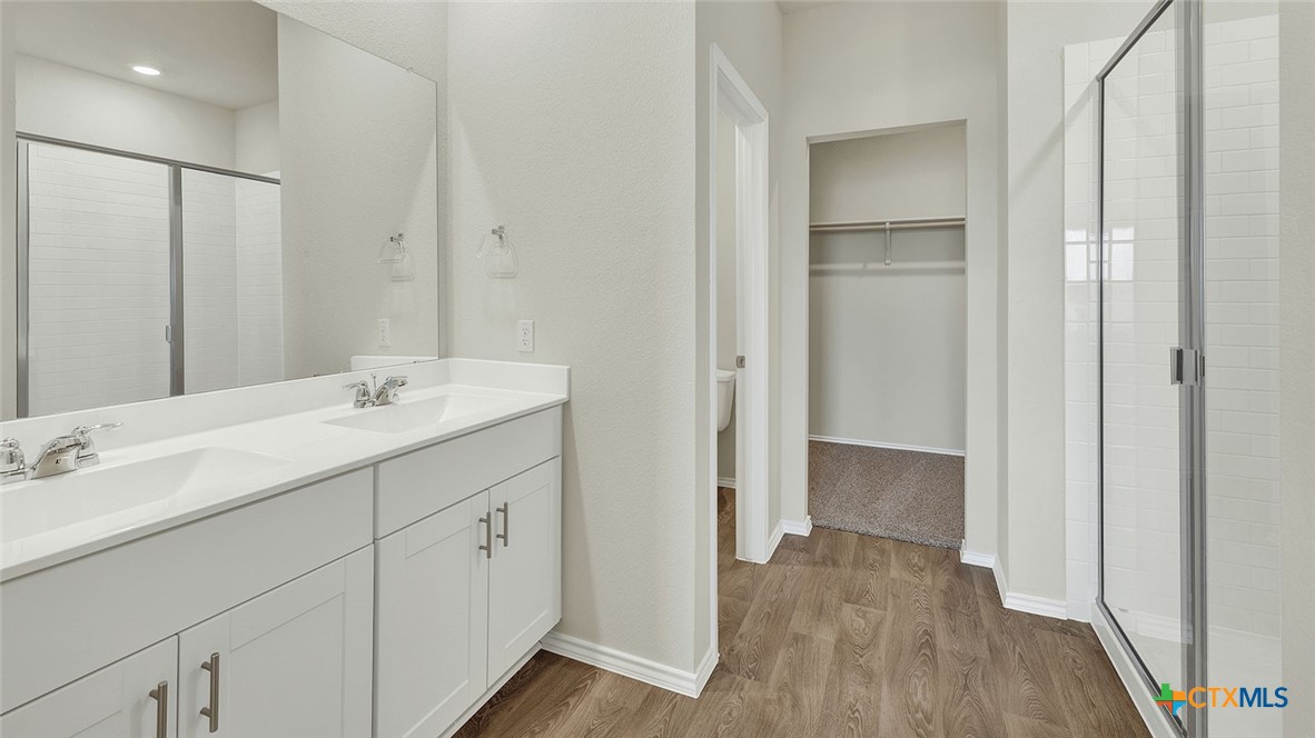 521 Hodges Street Lockhart, TX 78644 - Photo 22 of 40 a spacious bathroom with a double vanity sink and mirror