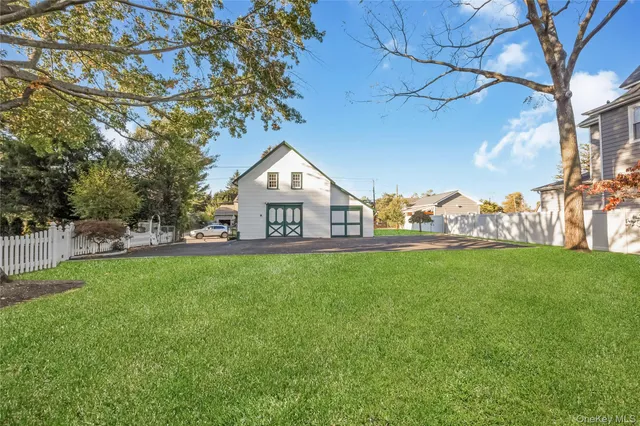 a view of a house with a big yard potted plants and large tree