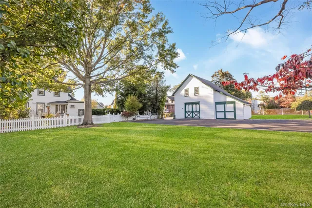 a view of a house with a big yard and large trees