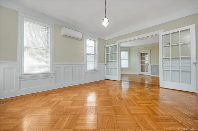 a view of an empty room with glass door and windows