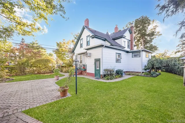 a view of a house with backyard and a tree