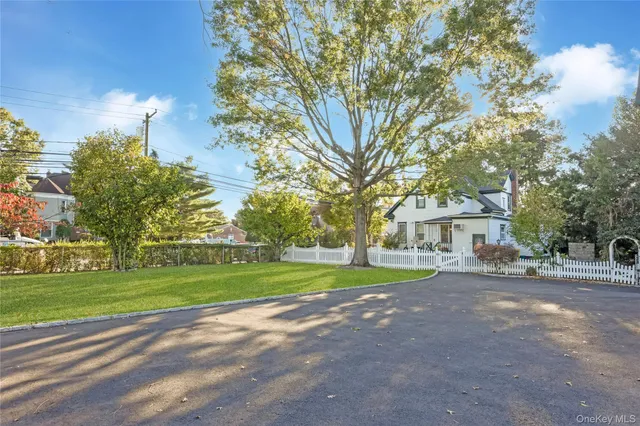 a view of a house with a big yard and large trees