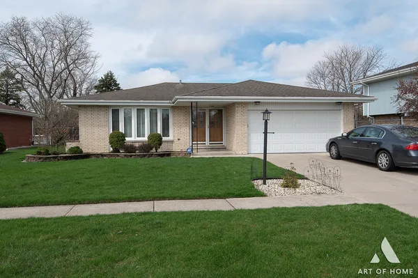 a front view of a house with a garden and trees
