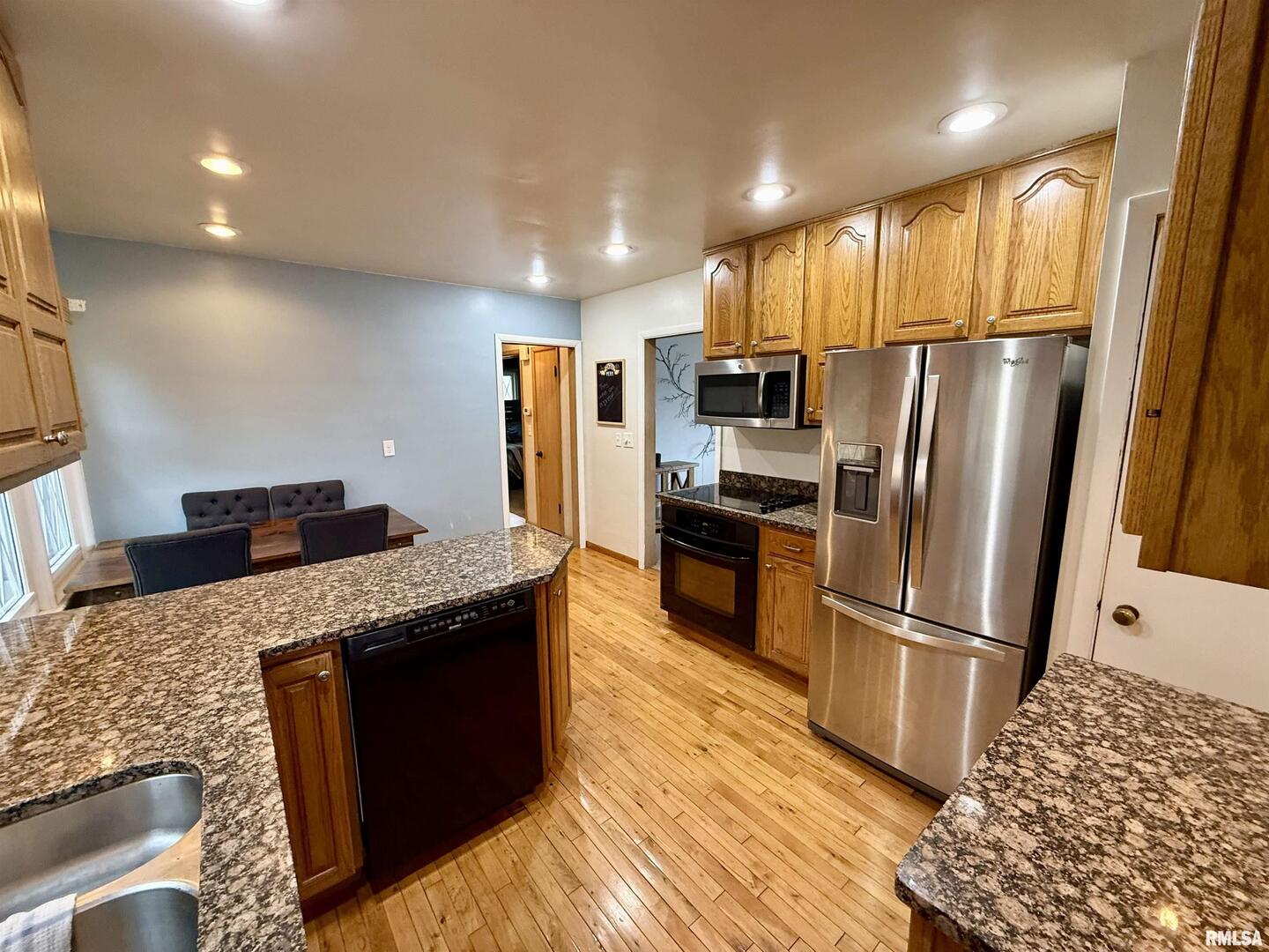 2003 19th Street Moline, IL 61265 - Photo 3 of 39 a kitchen with granite countertop a refrigerator and a stove top oven