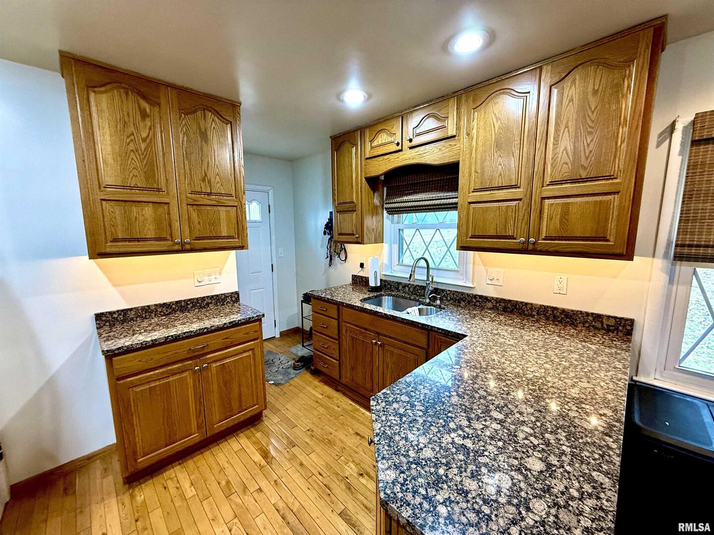 2003 19th Street Moline, IL 61265 - Photo 4 of 39 a kitchen with stainless steel appliances granite countertop wooden cabinets and a stove top oven