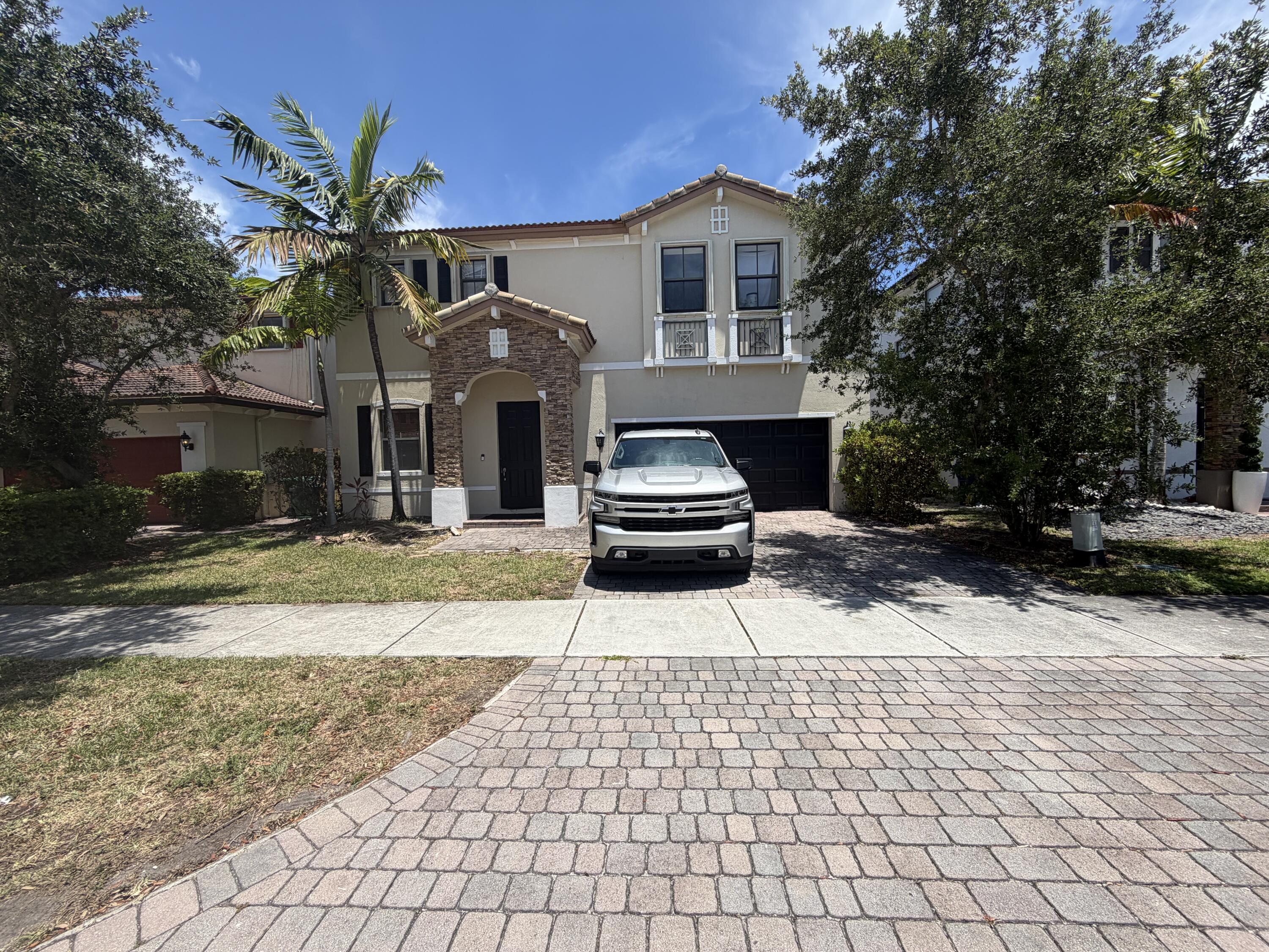 10463 Southwest 228th Terrace Miami, FL 33190 - Photo 1 of 8 a front view of a house with a yard