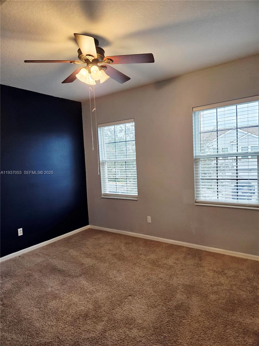 9181 Shepton Street, Unit 9181 Orlando, FL 32825 - Photo 33 of 41 an empty room with windows and chandelier fan