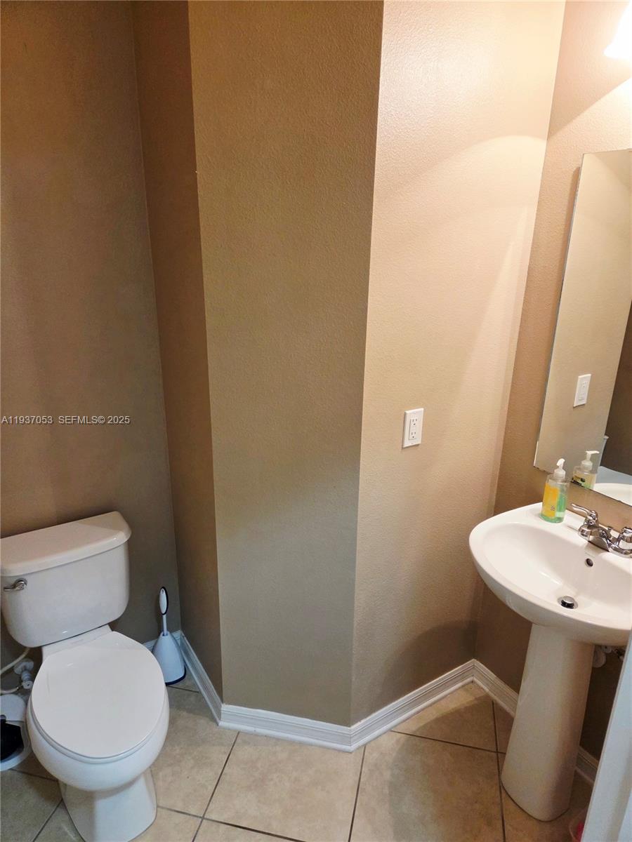 9181 Shepton Street, Unit 9181 Orlando, FL 32825 - Photo 4 of 41 a white toilet sitting next to a bathroom sink