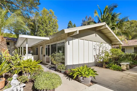 a front view of a house with a yard with potted plants