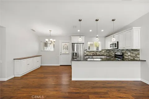 a large white kitchen with kitchen island a sink a stove and a refrigerator