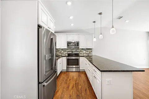 a kitchen with kitchen island a counter top space a sink and stainless steel appliances