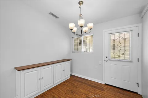 a view of a room with wooden floor and chandelier