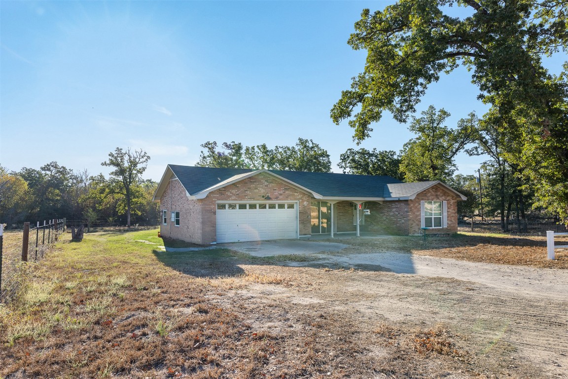 139 Farm To Market 696 Elgin, TX 78621 - Photo 1 of 27 Ranch-style home featuring brick siding, a porch, driveway, and a garage