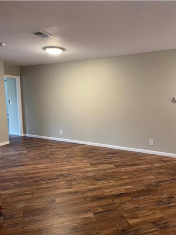 139 Farm To Market 696 Elgin, TX 78621 - Photo 13 of 27 Spare room featuring dark wood-type flooring and baseboards