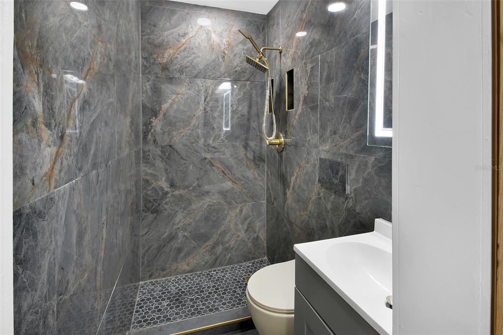 1015 East Howry Avenue Deland, FL 32724 - Photo 12 of 26 a bathroom with a sink a toilet and shower