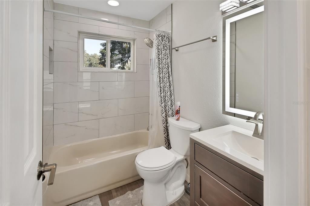 1015 East Howry Avenue Deland, FL 32724 - Photo 15 of 26 a bathroom with a sink a toilet and shower