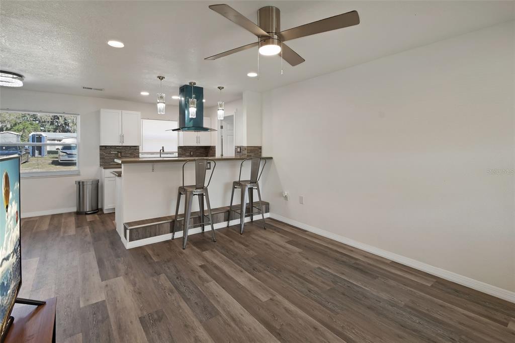 1015 East Howry Avenue Deland, FL 32724 - Photo 3 of 26 a view of kitchen with refrigerator microwave and wooden floor