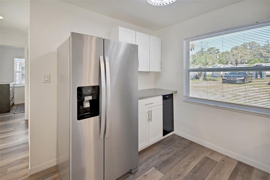 1015 East Howry Avenue Deland, FL 32724 - Photo 7 of 26 a kitchen with stainless steel appliances a refrigerator sink and cabinets
