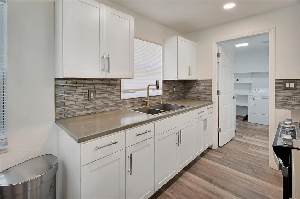 1015 East Howry Avenue Deland, FL 32724 - Photo 8 of 26 a kitchen with stainless steel appliances granite countertop a sink stove and cabinets