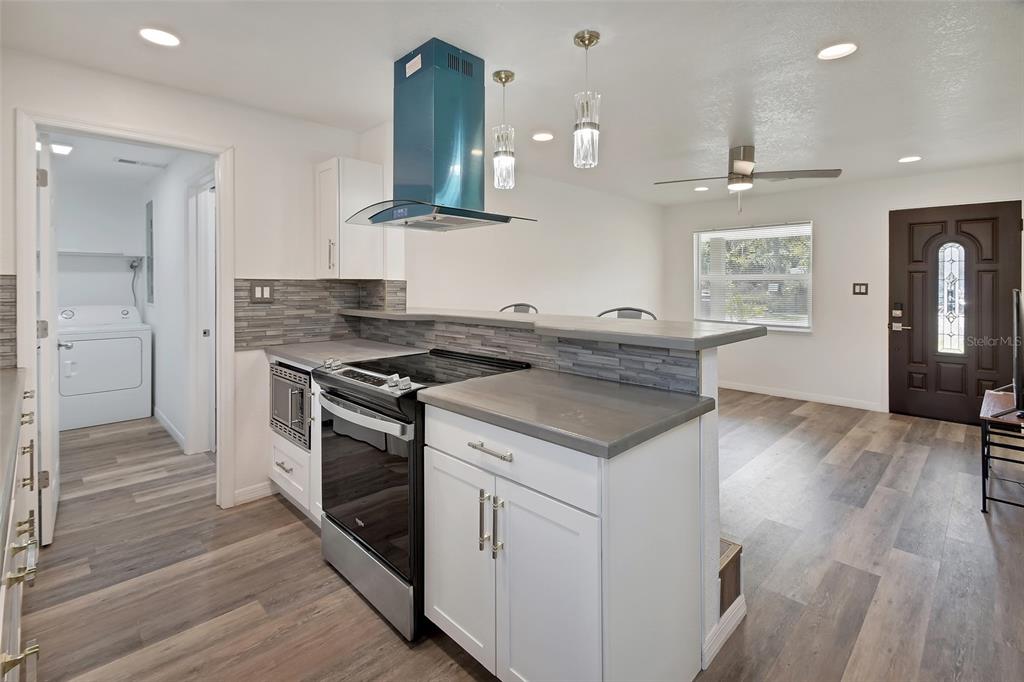 1015 East Howry Avenue Deland, FL 32724 - Photo 9 of 26 a kitchen with a stove a sink and a refrigerator