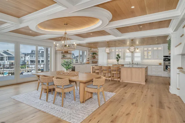 a kitchen with stainless steel appliances granite countertop a stove top oven a sink dishwasher white cabinets with wooden floor