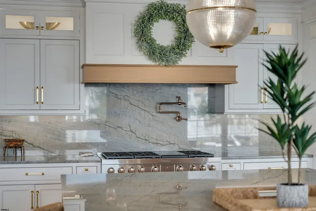 a kitchen with stainless steel appliances granite countertop a sink a stove and cabinets