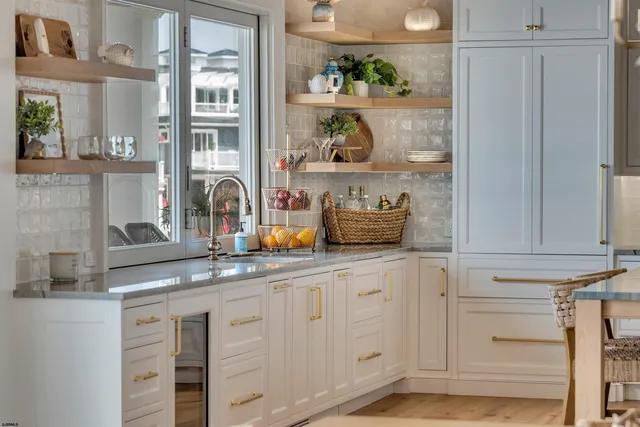 a kitchen with granite countertop white cabinets and white stainless steel appliances