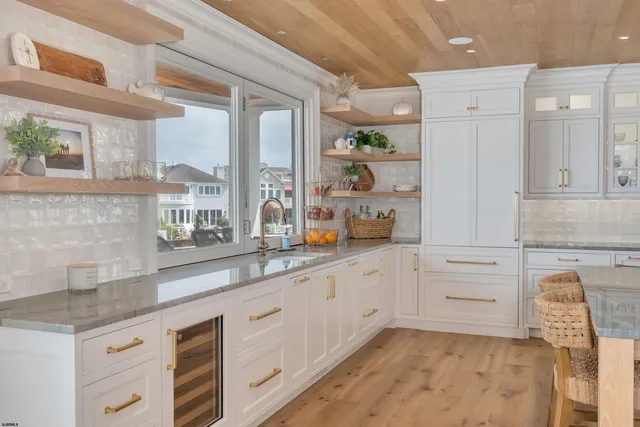 a kitchen with stainless steel appliances white cabinets and wooden floor