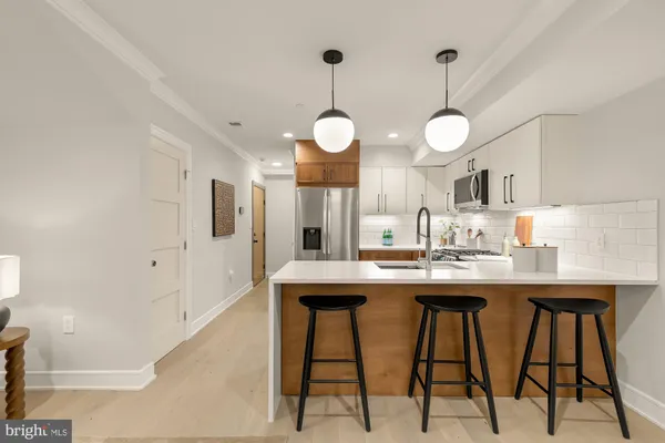 a kitchen with stainless steel appliances kitchen island a table and chairs in it
