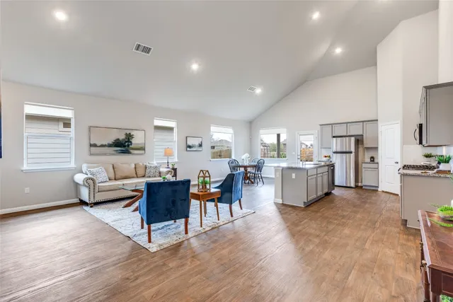 a kitchen with kitchen island granite countertop a stove sink and refrigerator