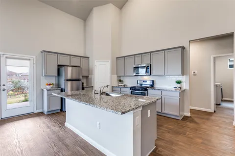 a kitchen with stainless steel appliances granite countertop a sink stove and refrigerator