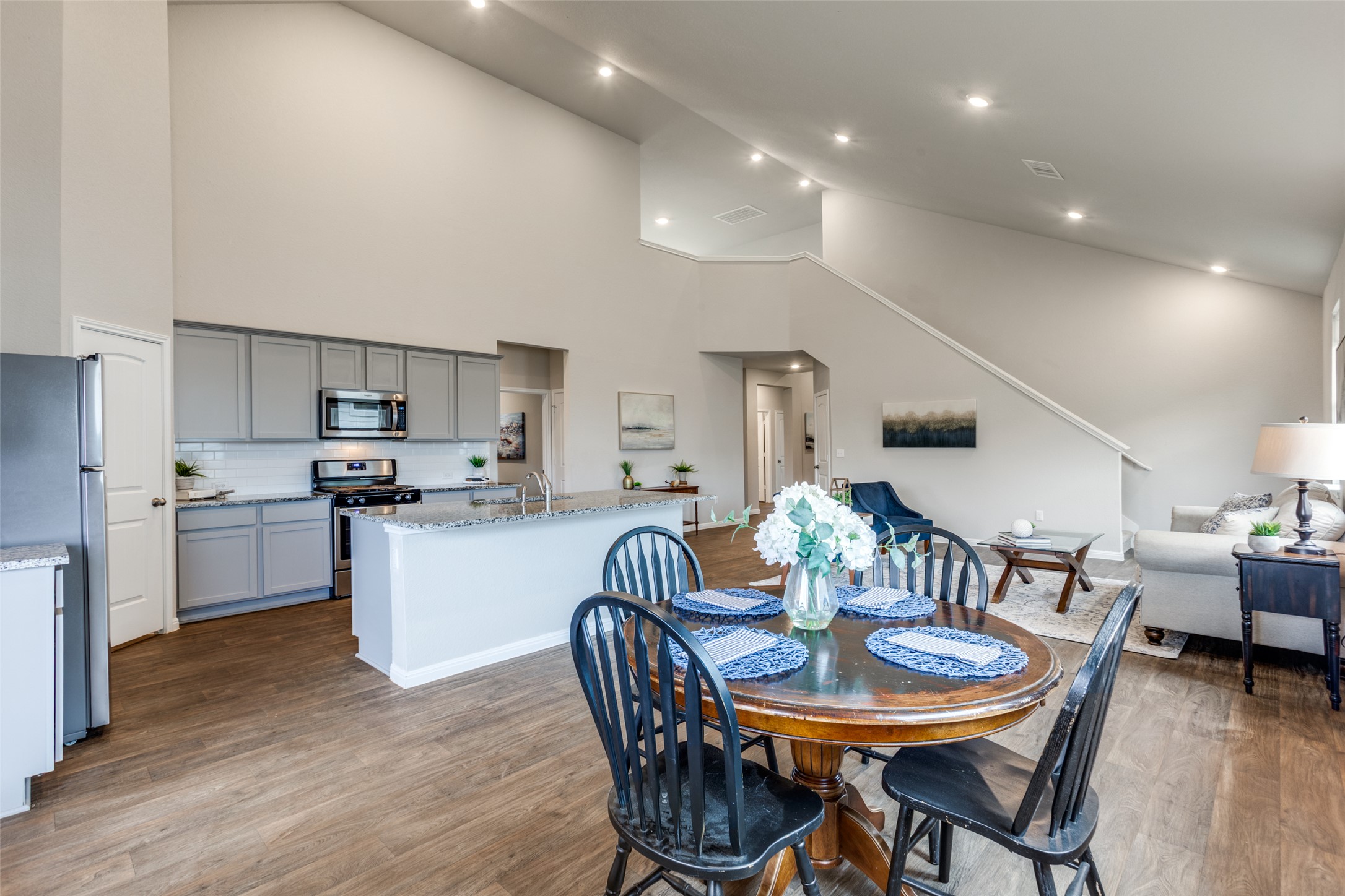 111 Rainmaker Cove Bastrop, TX 78602 - Photo 10 of 36 a kitchen with stainless steel appliances kitchen island granite countertop a dining table chairs and a refrigerator