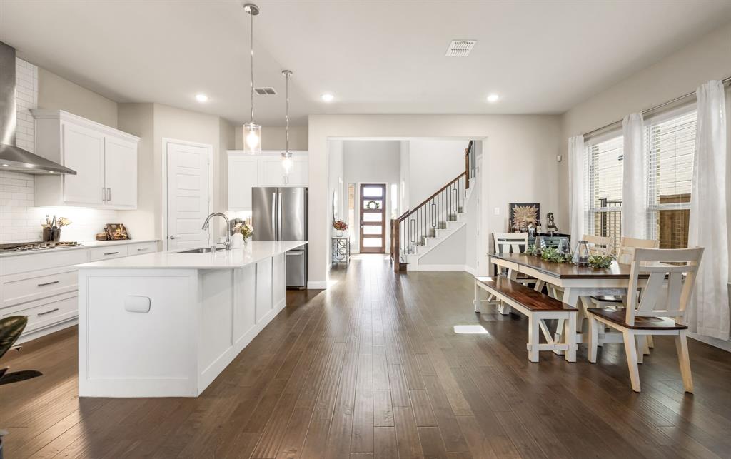 2270 English Ivy Road Frisco, TX 75033 - Photo 7 of 39 a kitchen with white cabinets and chairs