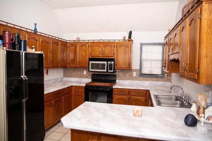 6736 Olivia Forest Road Memphis, TN 38141 - Photo 10 of 18 a kitchen with wooden cabinets a sink and a stove